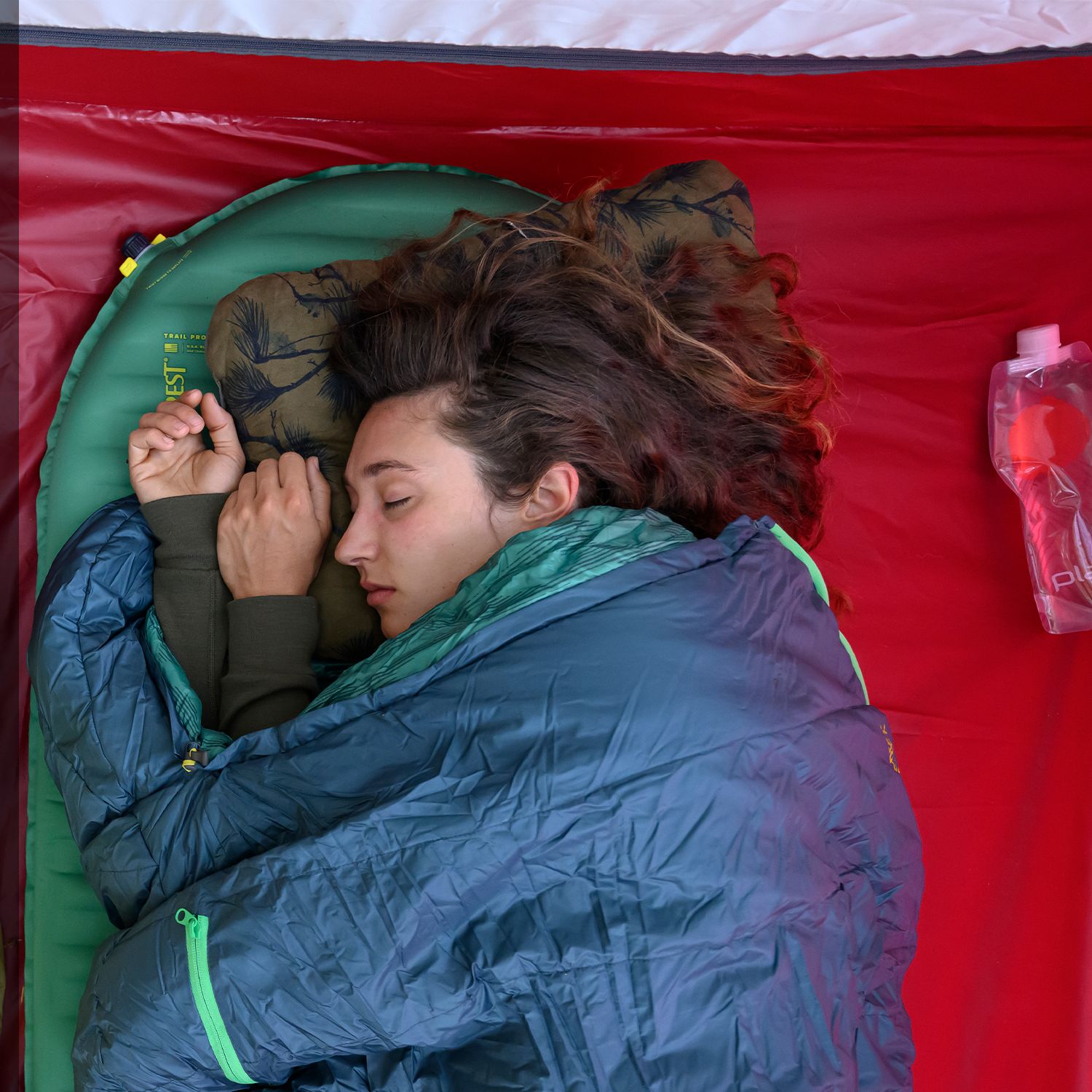 Two campers asleep on Therm-a-Rest pads and bags